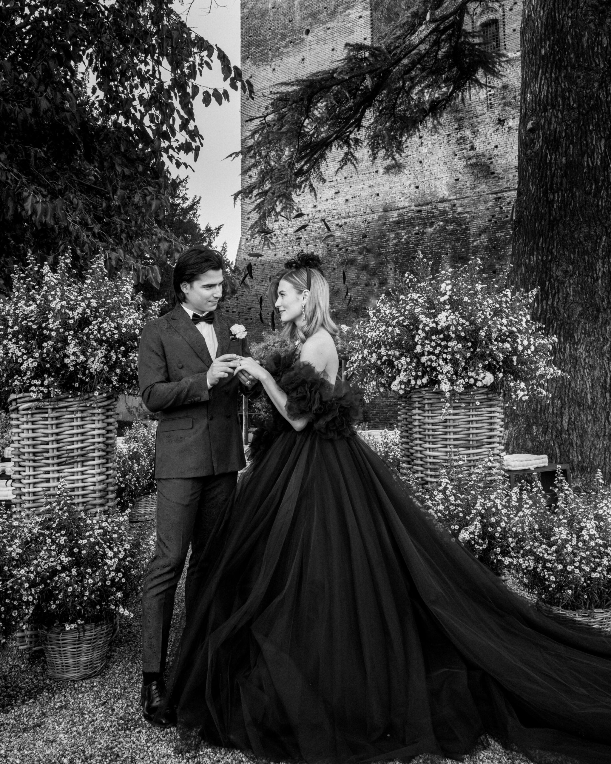 A couple stands in an outdoor setting, surrounded by opulent flower arrangements at their luxury wedding A couple stands in an outdoor setting, surrounded by opulent flower arrangements at their luxury wedding