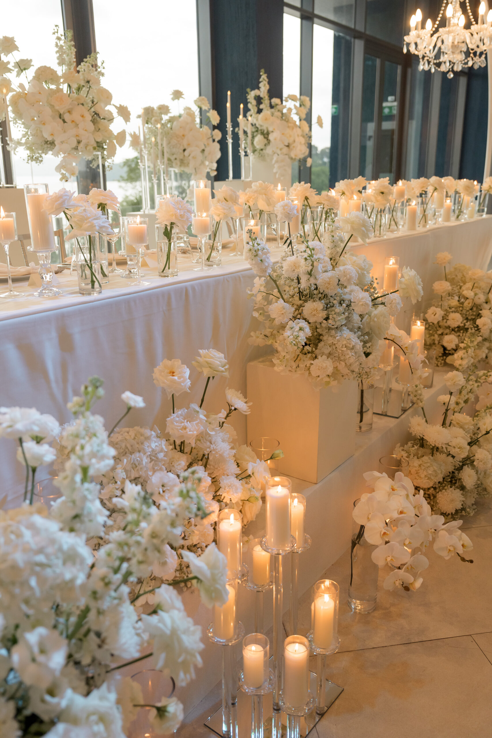 Elegant wedding decor featuring white flowers and numerous lit candles Elegant wedding decor featuring white flowers and numerous lit candles