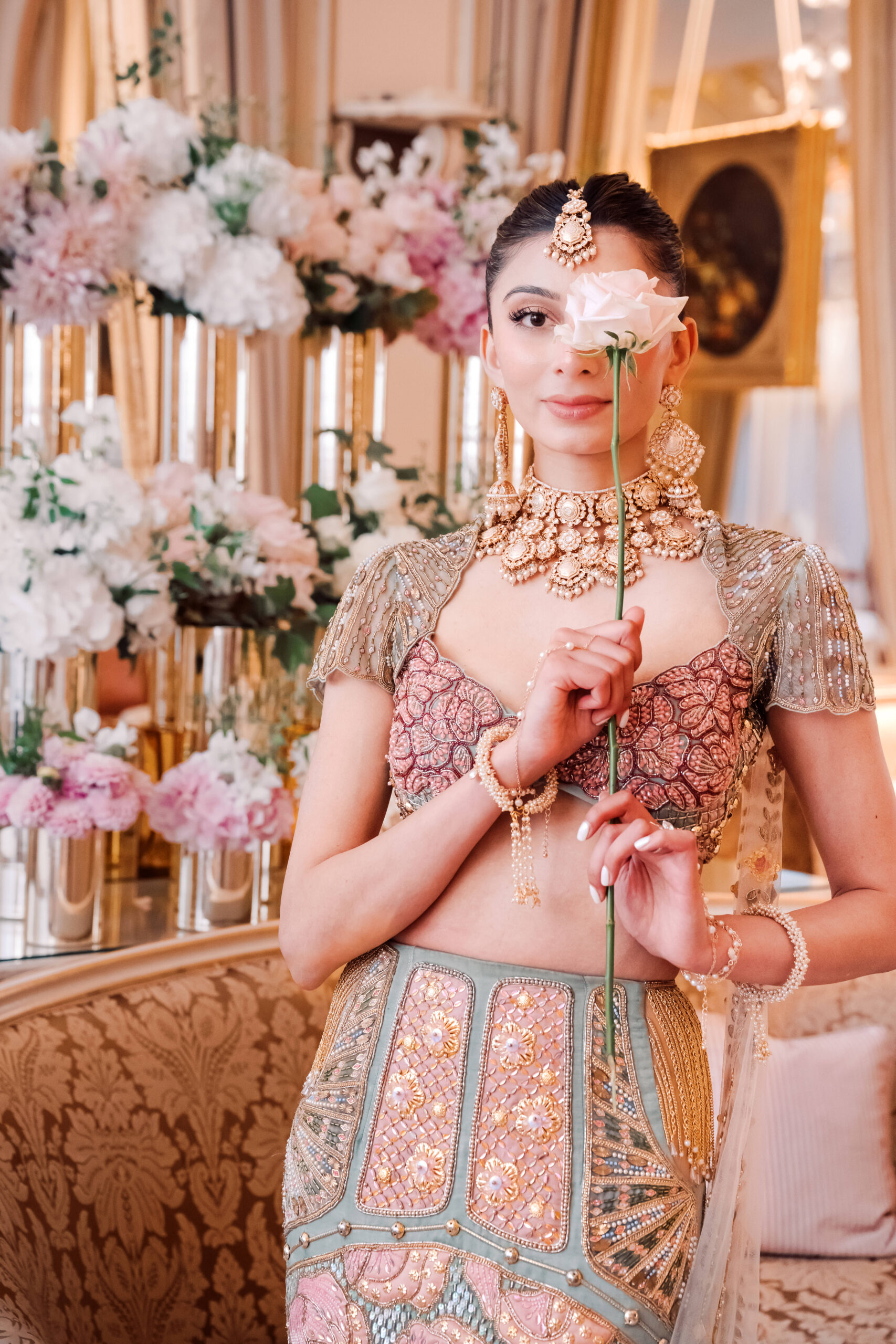 pink and gold indian dress A woman in an ornate, traditional outfit holds a pale rose in front of traditional indian sari dress