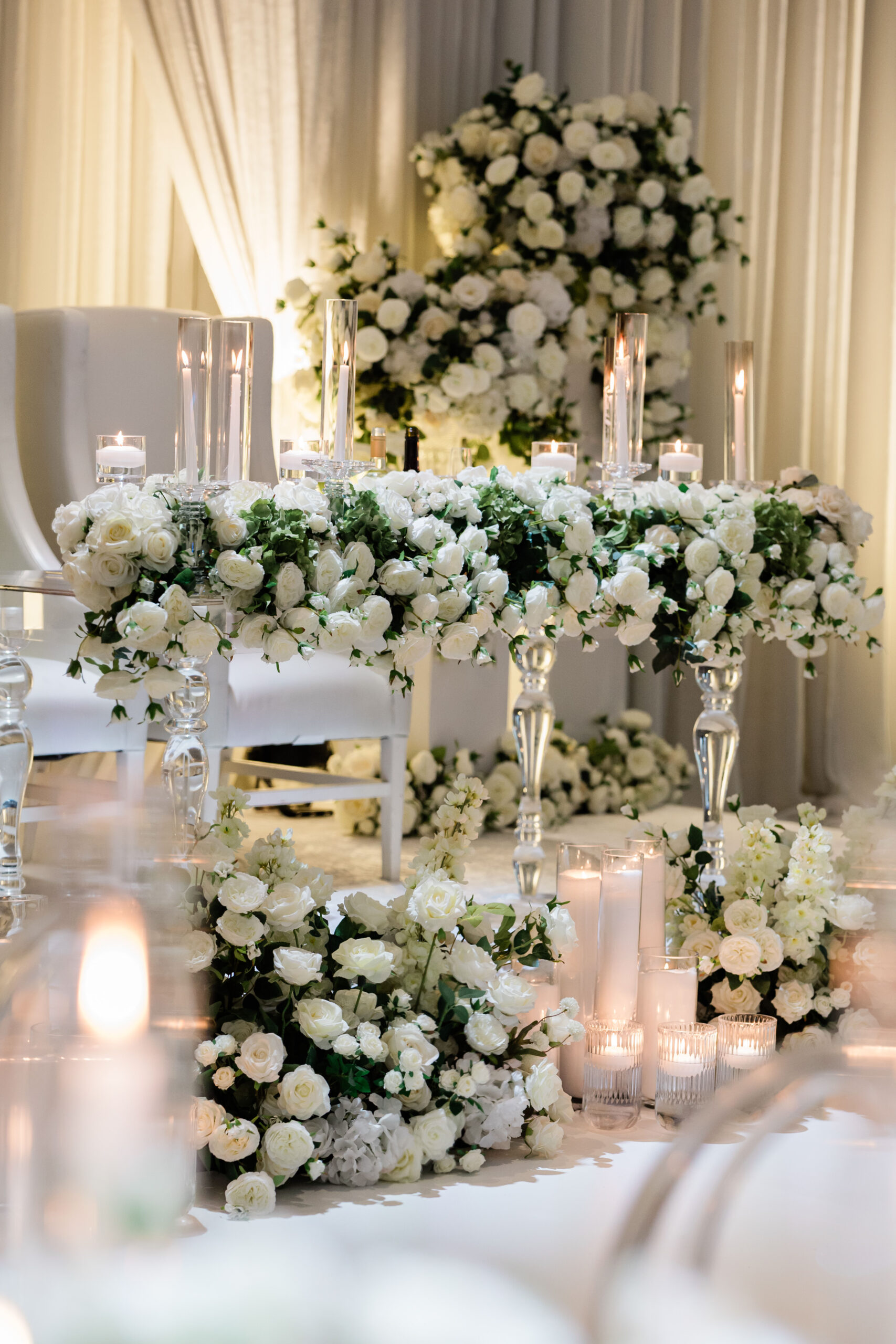 Elegant wedding decor featuring a table adorned with white roses ...