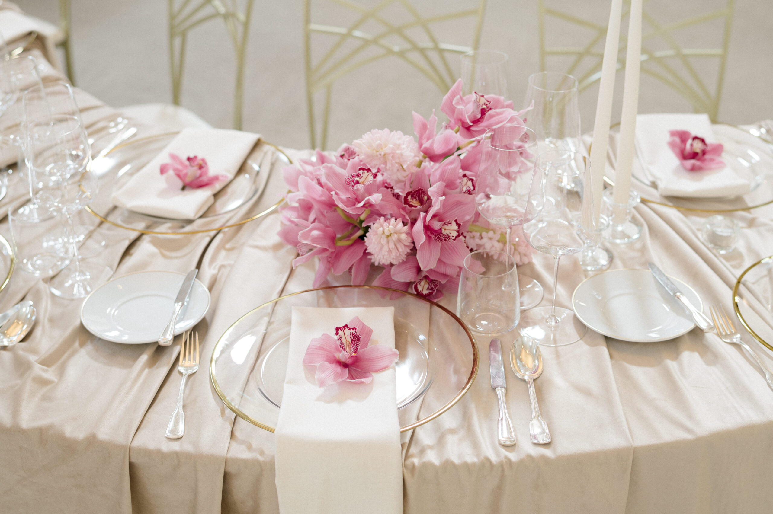 Elegant table setting with cream-colored tablecloth, gold-rimmed plates ...