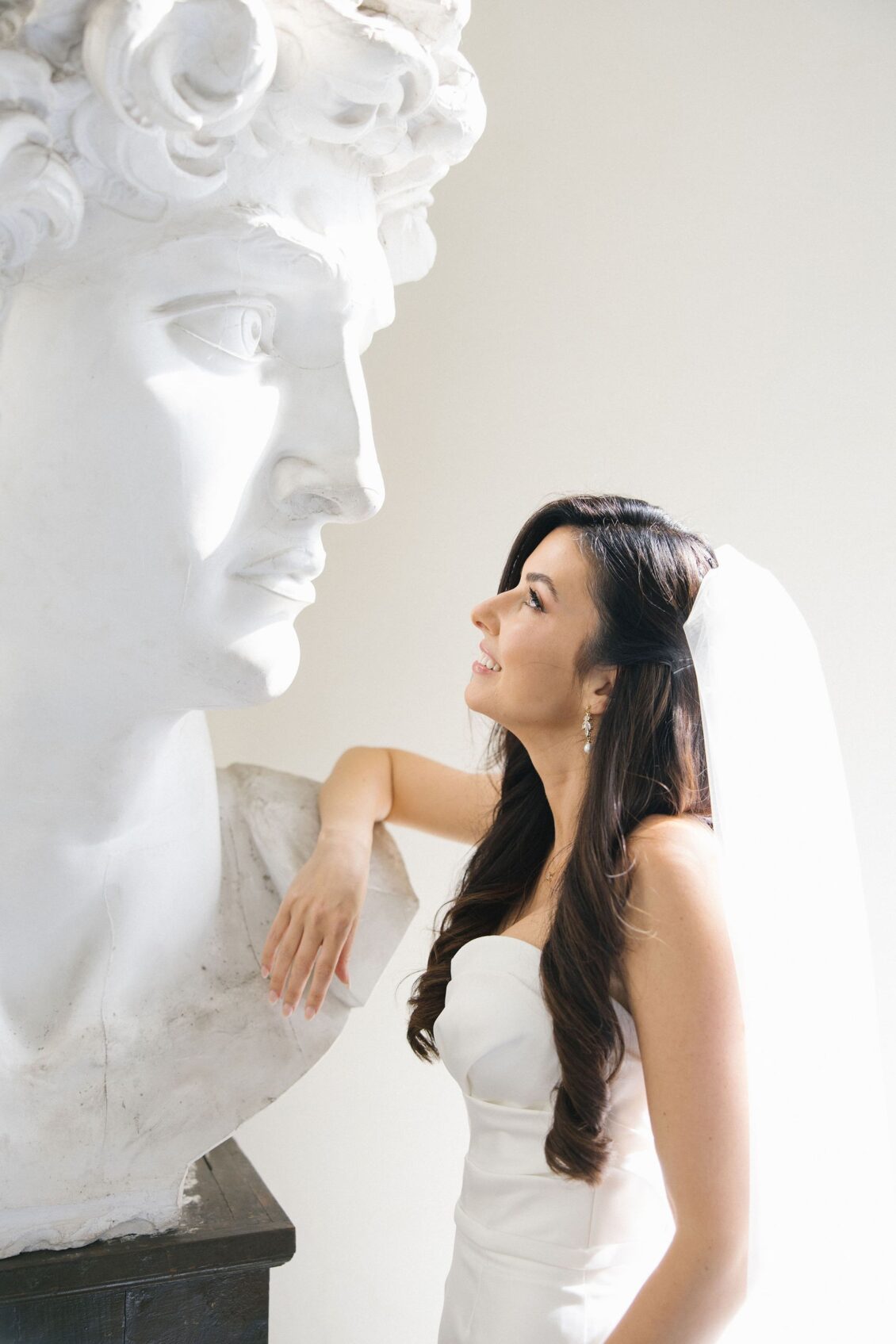 Editorial bridal portrait beside a classical sculpture at Villa Pazzi al Parugiano