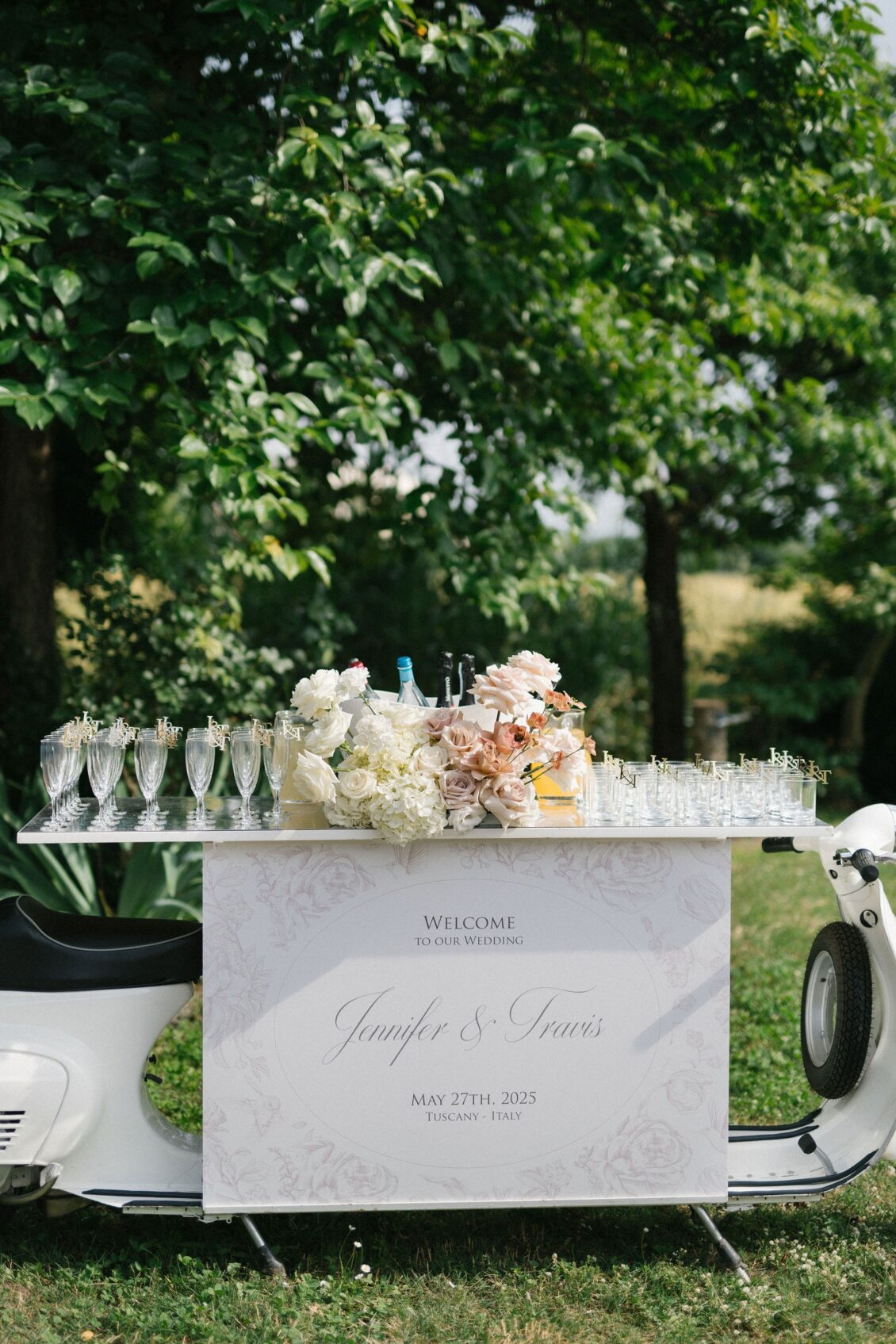 White Vespa welcome display with champagne and blush flowers