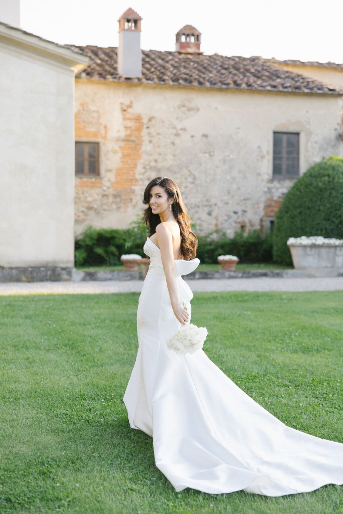 Jennifer crossing the lawn in her sculptural wedding gown