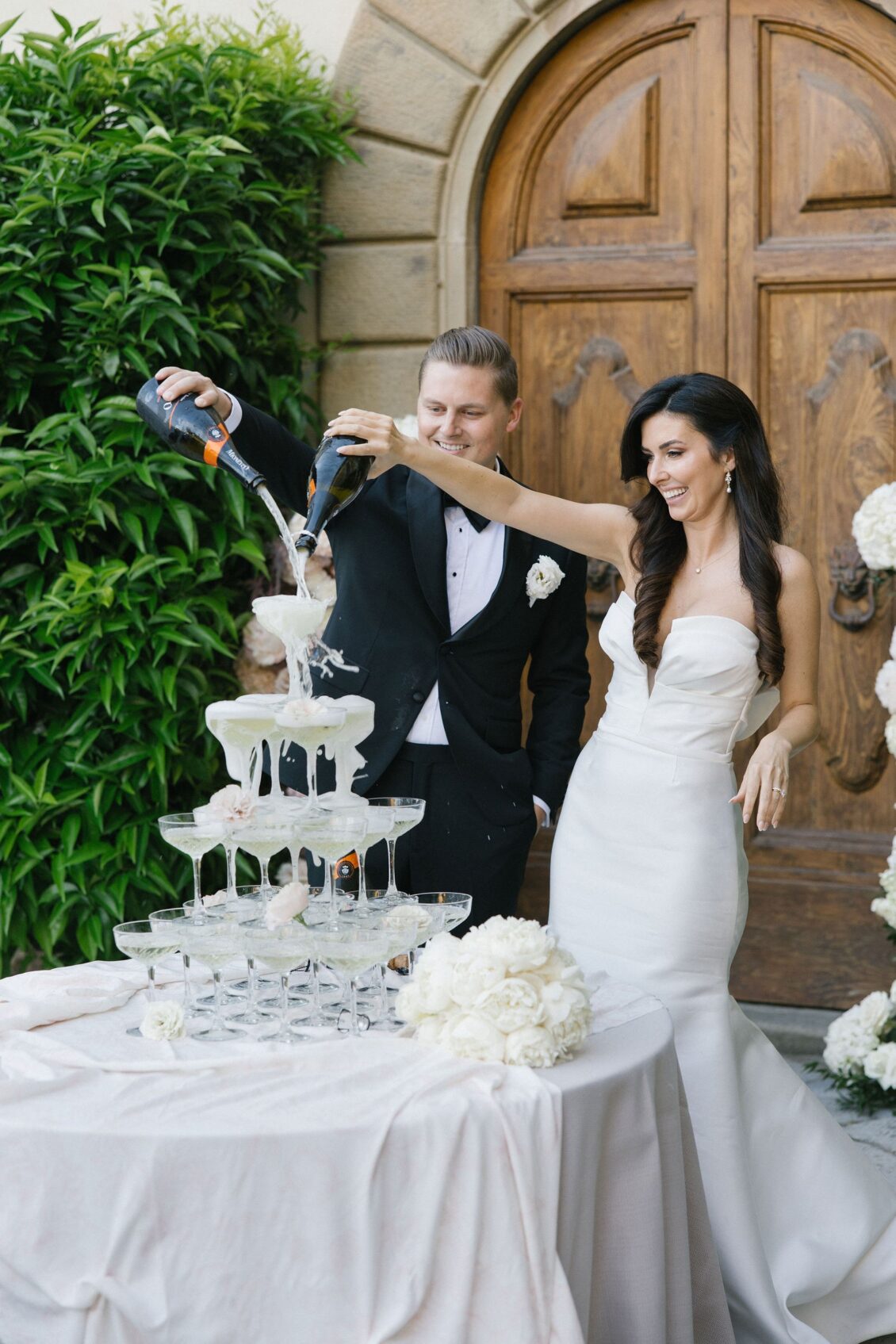 Jennifer and Travis pouring champagne into their wedding tower