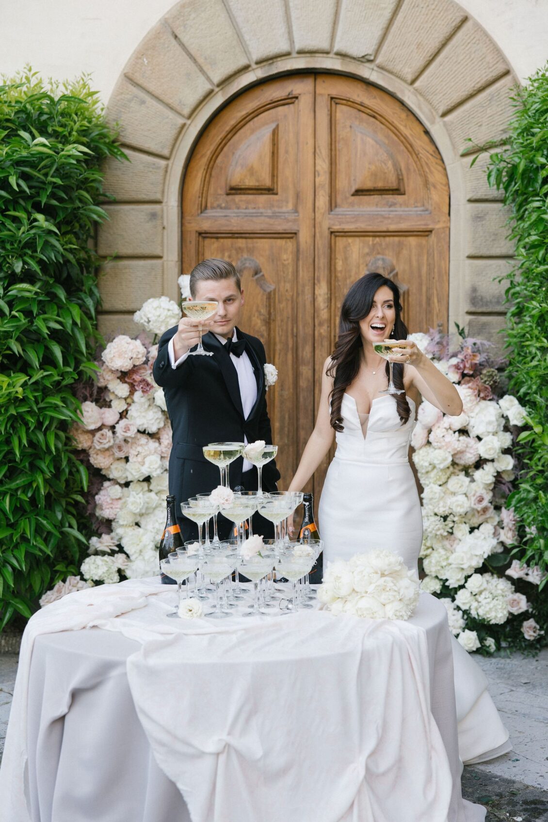 Jennifer and Travis toasting beside the champagne tower