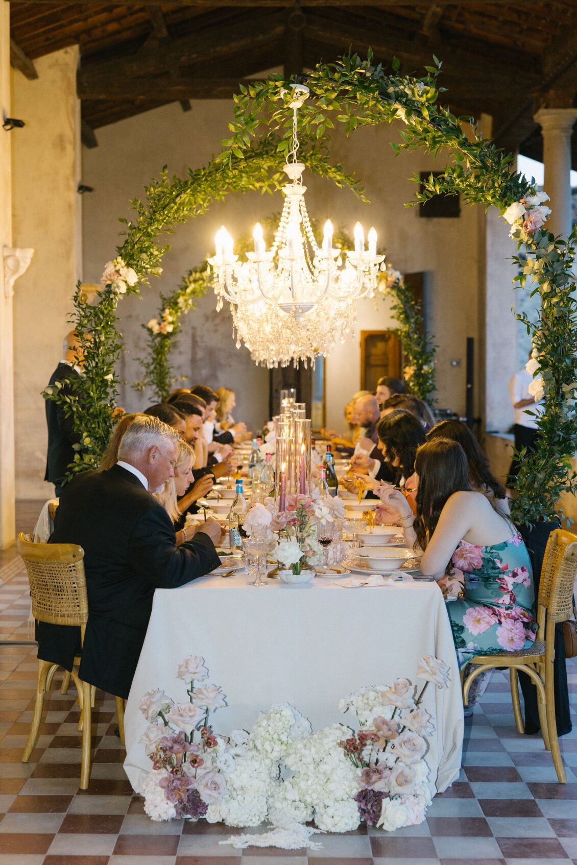 Guests dining beneath crystal chandeliers in the villa altana