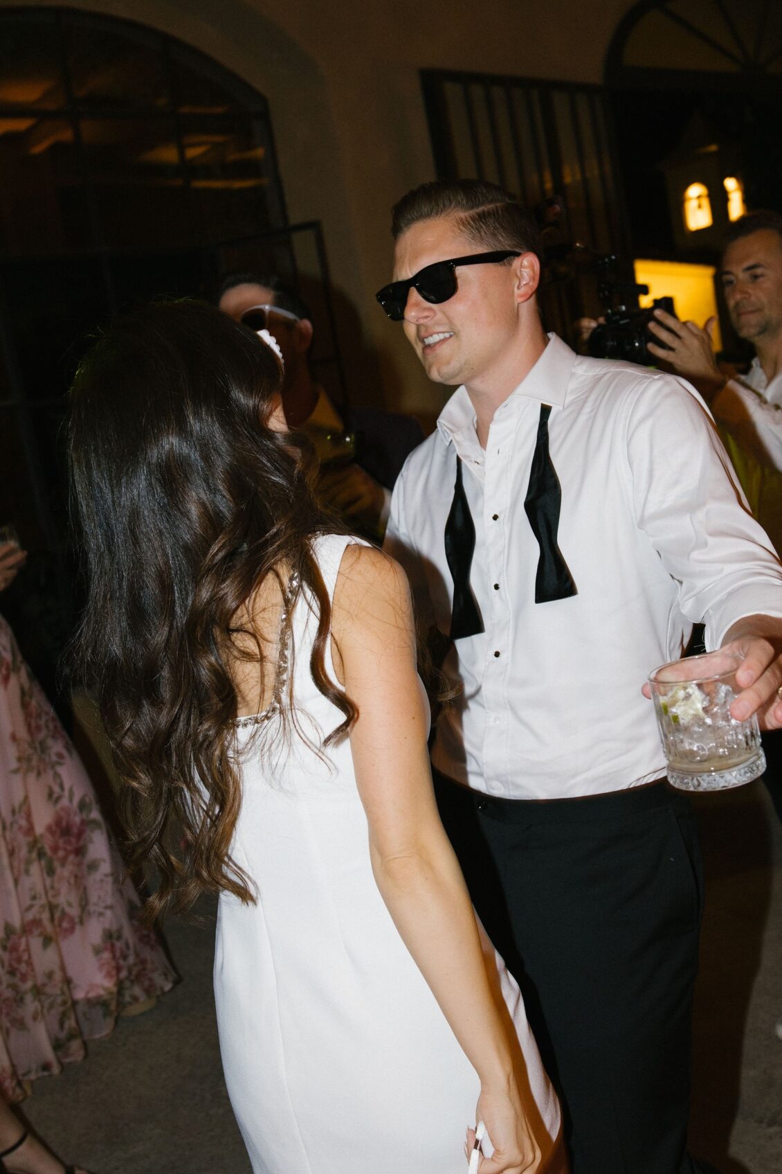 Travis dancing in sunglasses with his bow tie undone