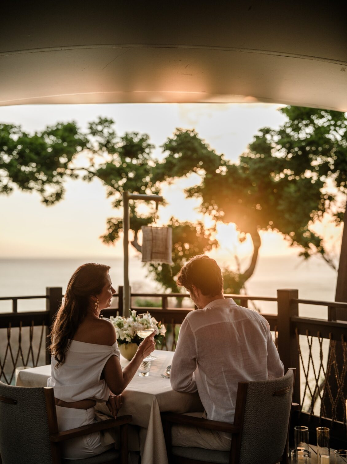 A couple shares a sunset dinner on a terrace overlooking the Pacific Ocean at Nekajui.