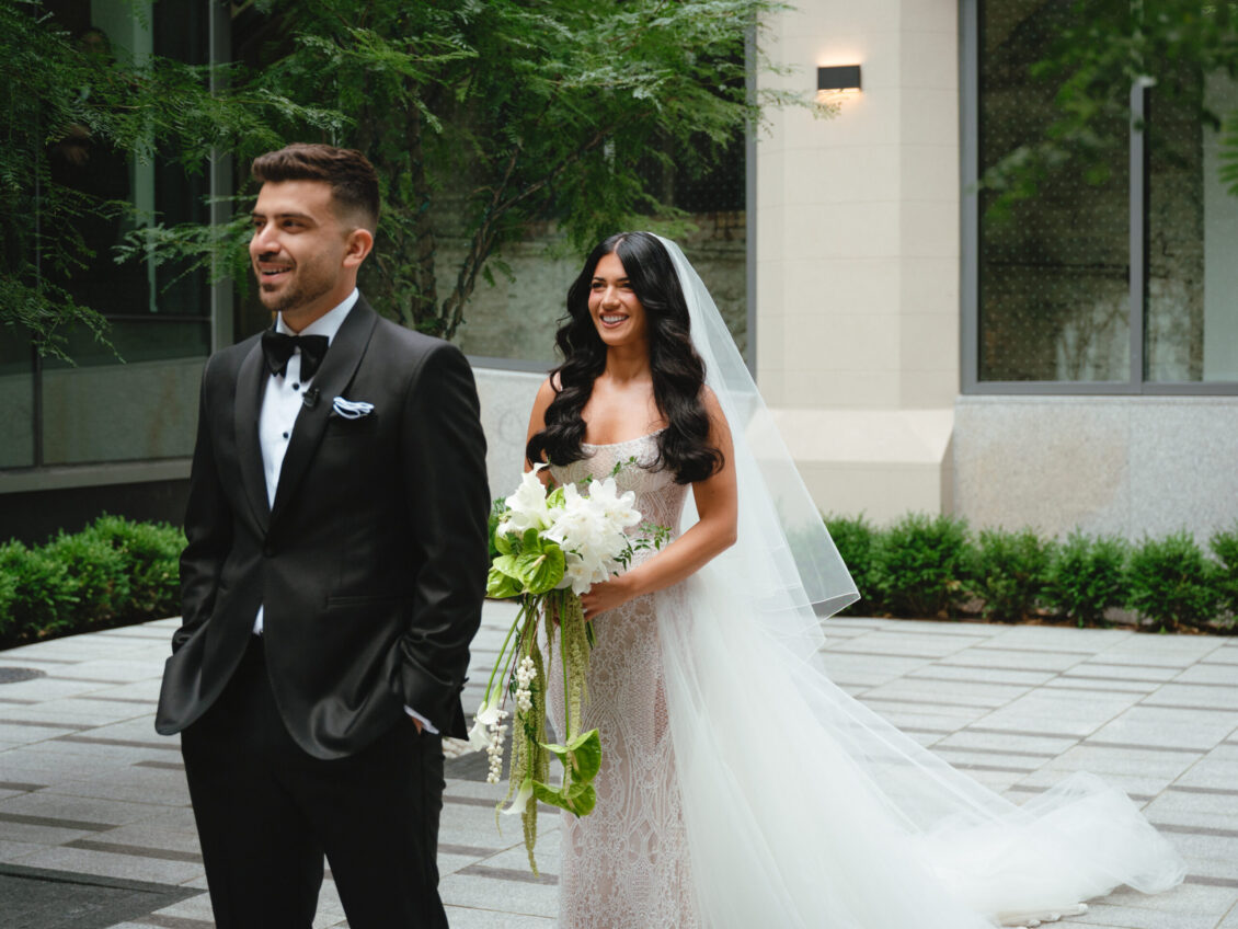 Cosimo walks with his hands in his pockets as Valerie carries her bouquet beside him with her veil and train trailing.