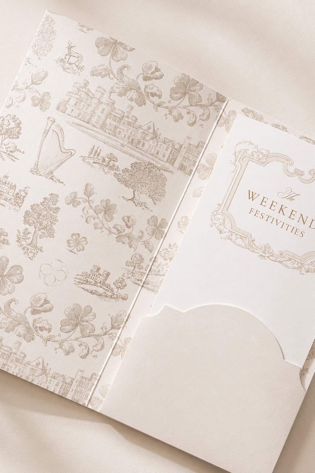 An elegant card folder with vintage-style illustrations holds an insert titled “Weekend Festivities” in gold script. The background is cream with light beige sketches of buildings, flowers, and a harp.