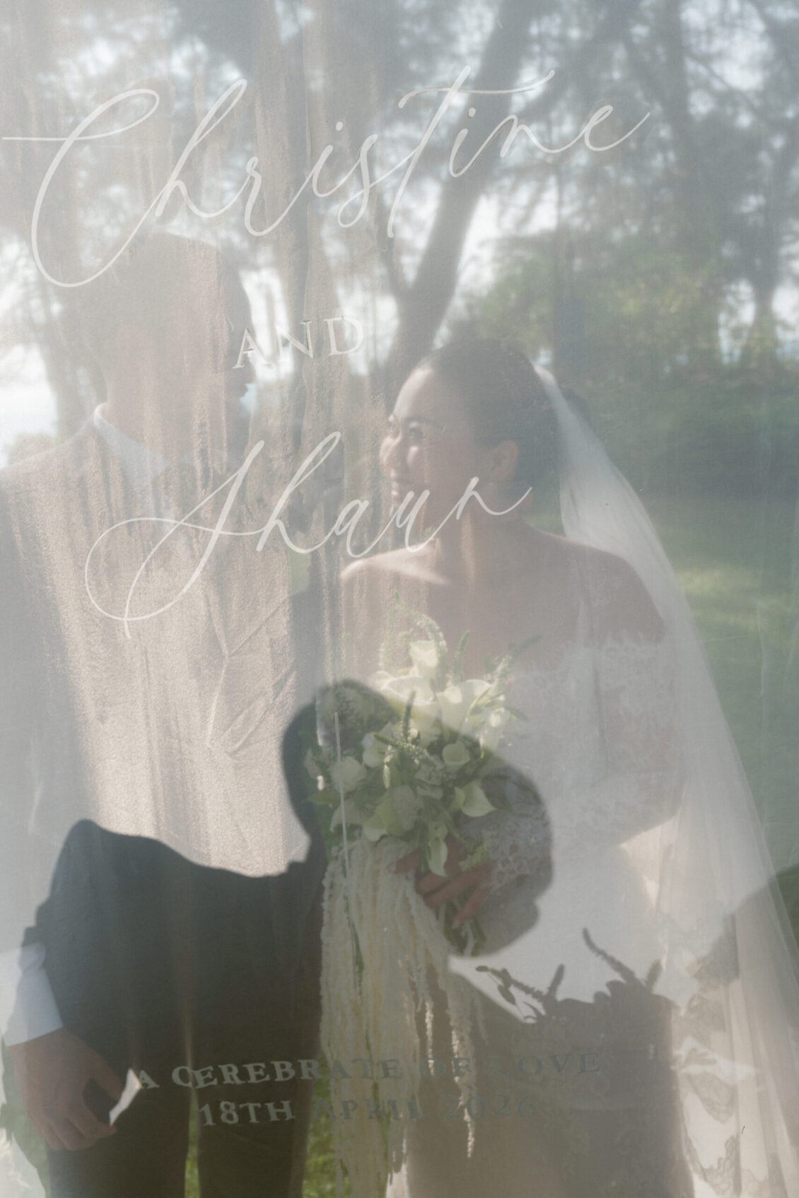 A bride and groom stand together outdoors behind a translucent fabric printed with “Christine and Sharir,” capturing the enchanting ambiance of a Renaissance Phuket wedding. The bride holds a bouquet of white flowers, while the image remains soft and dreamlike.