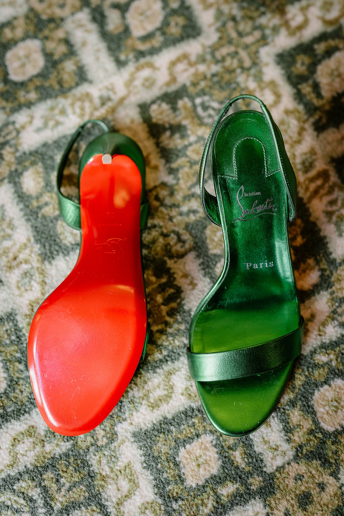 A pair of green Christian Louboutin sandals with signature red soles placed on a patterned carpet, perfect for an elegant Irish castle wedding at Ashford Castle.