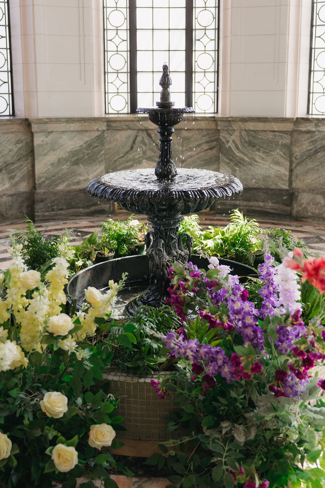 Tiered fountain framed by abundant colourful flowers