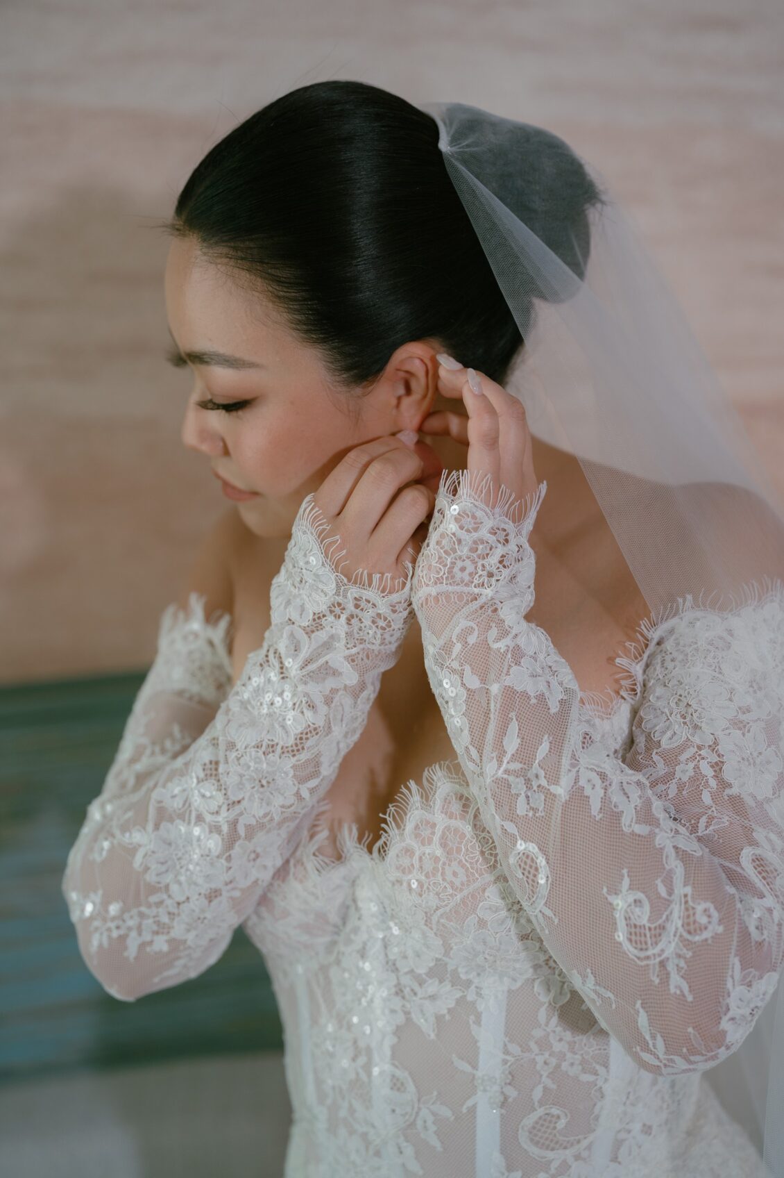 Christine and Shaun's Phuket wedding, earring adjustment records the final bridal finishing touch with clean hand placement.