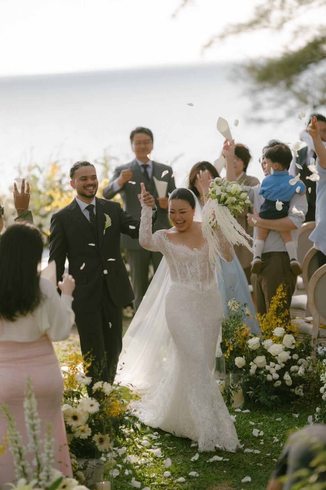 Christine and Shaun's Phuket wedding, bride’s raised-arm gesture gives the recessional a distinct, exuberant second beat.