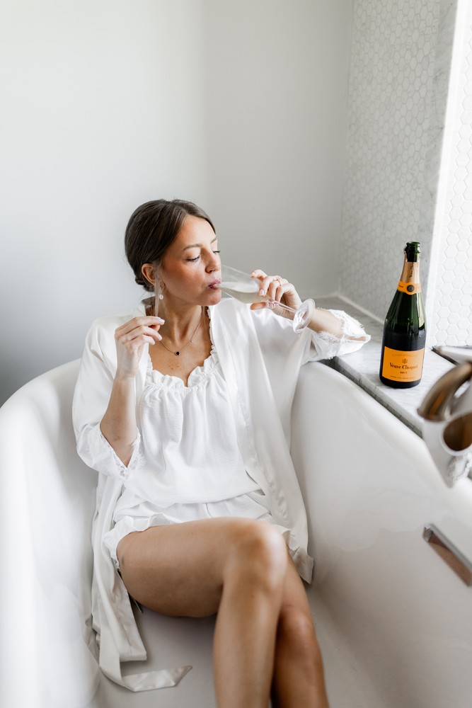 Marta and Eric at Elora Mill — bride champagne bathtub — photographed by Rose Vine Studios