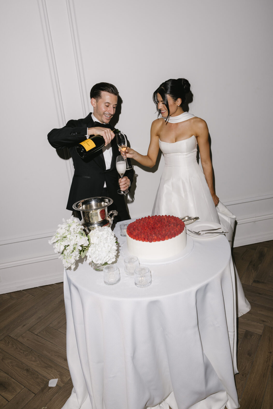 Erica and Anthony celebrate beside their wedding cake.