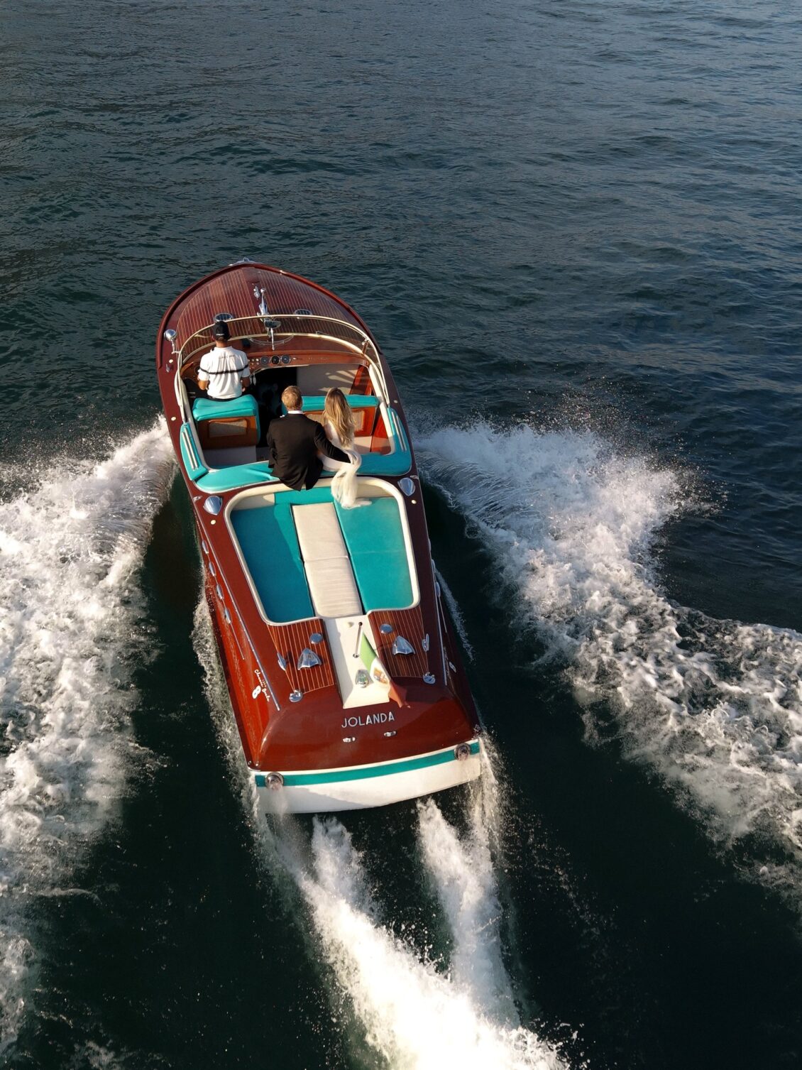Boat carrying the newlyweds leaves a white wake across Lake Como.