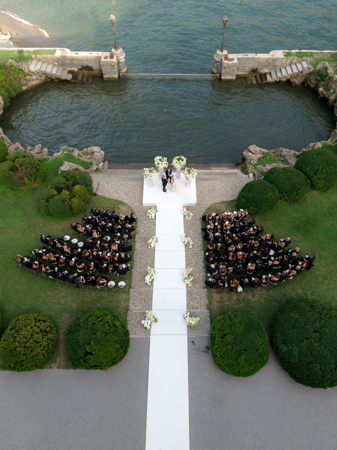 Newlyweds and attendants stand at the lakeside ceremony altar.