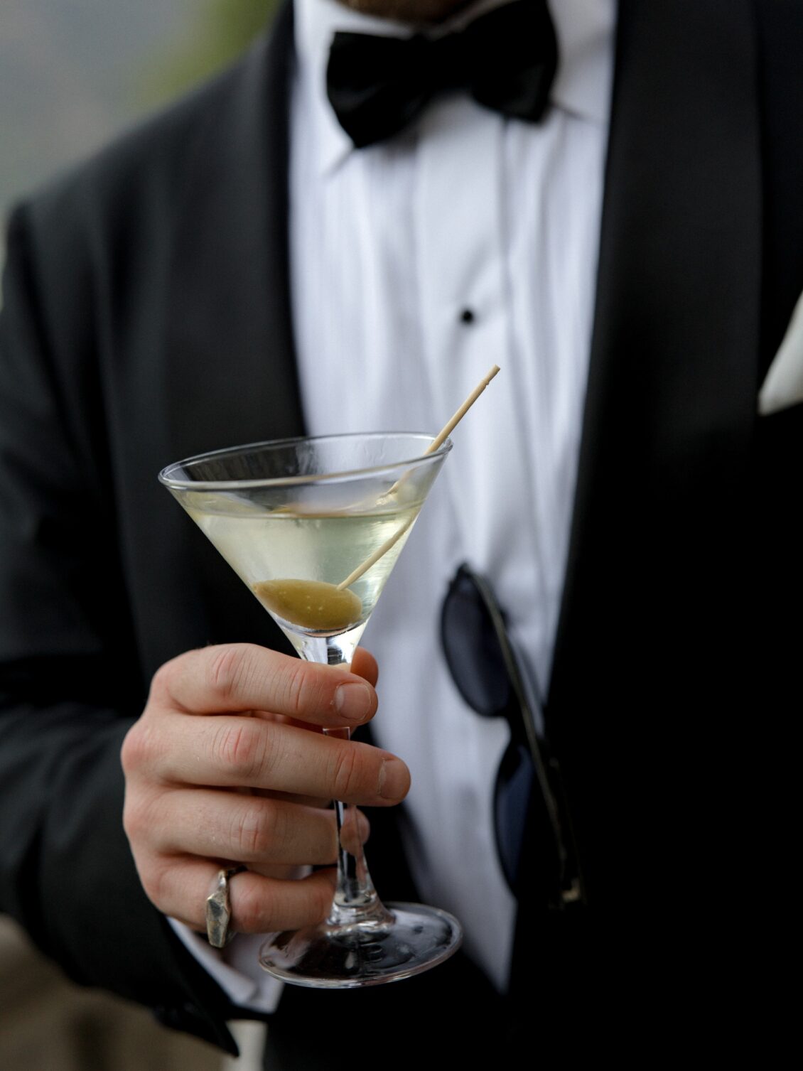Martini held by a guest in black tie