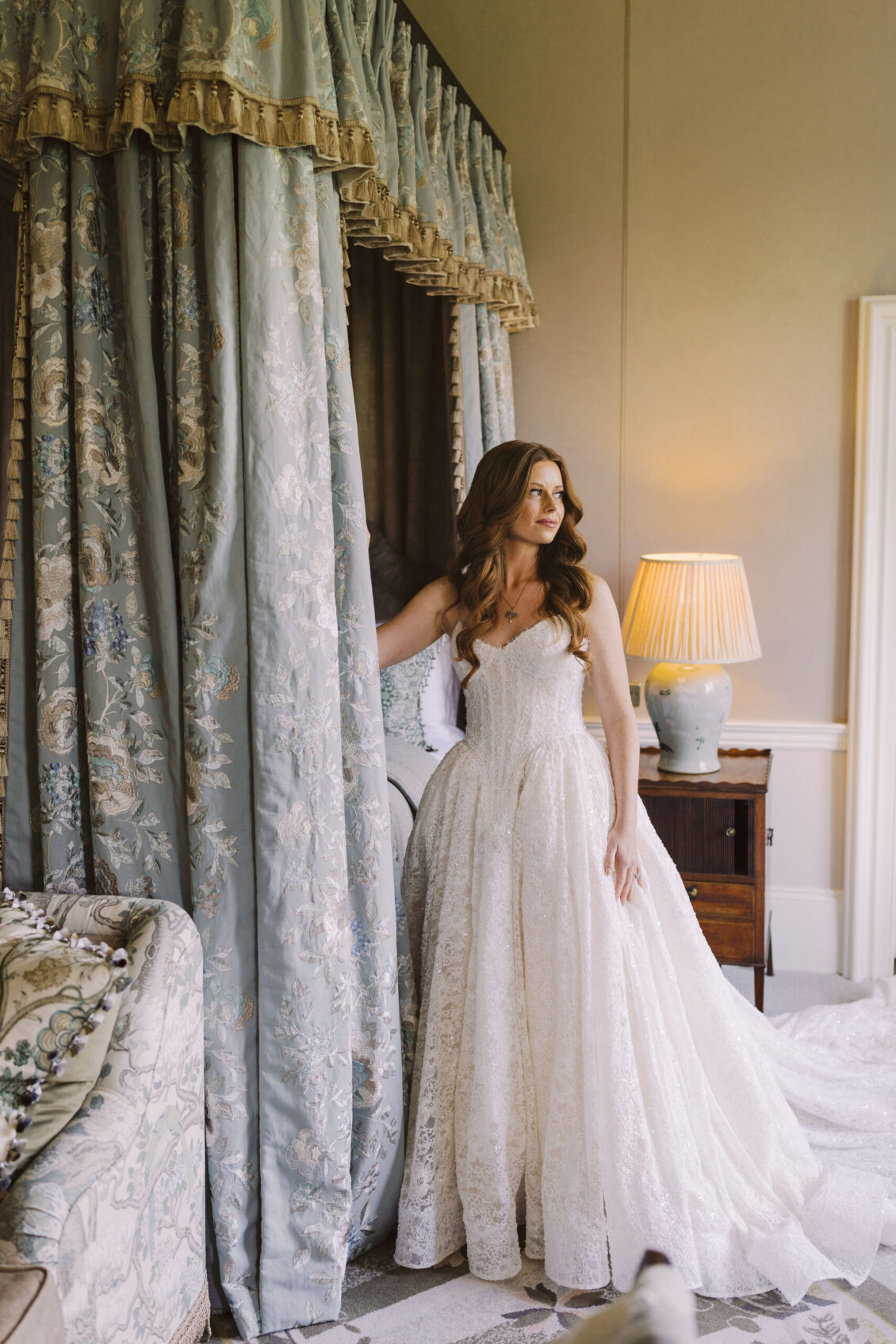 Bride beside draped windows in a bedroom at Luttrellstown Castle Resort