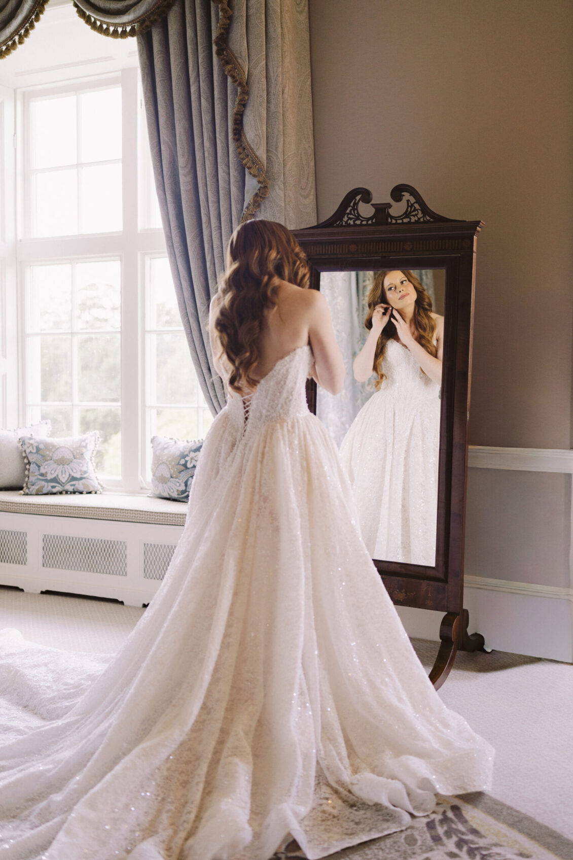 Bride admiring her gown in a mirror at Luttrellstown Castle Resort