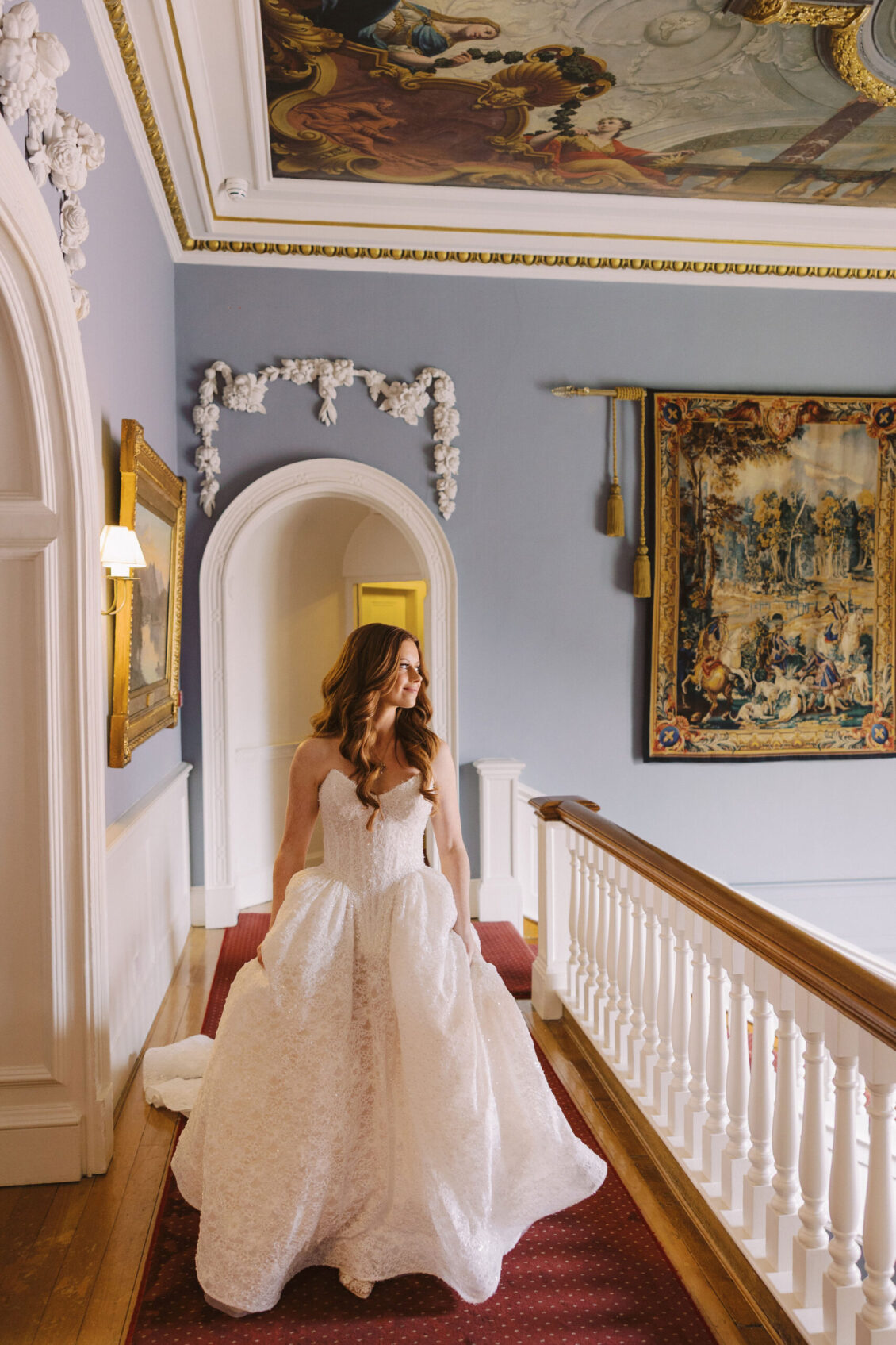 Bride on a tapestry-lined staircase at Luttrellstown Castle Resort