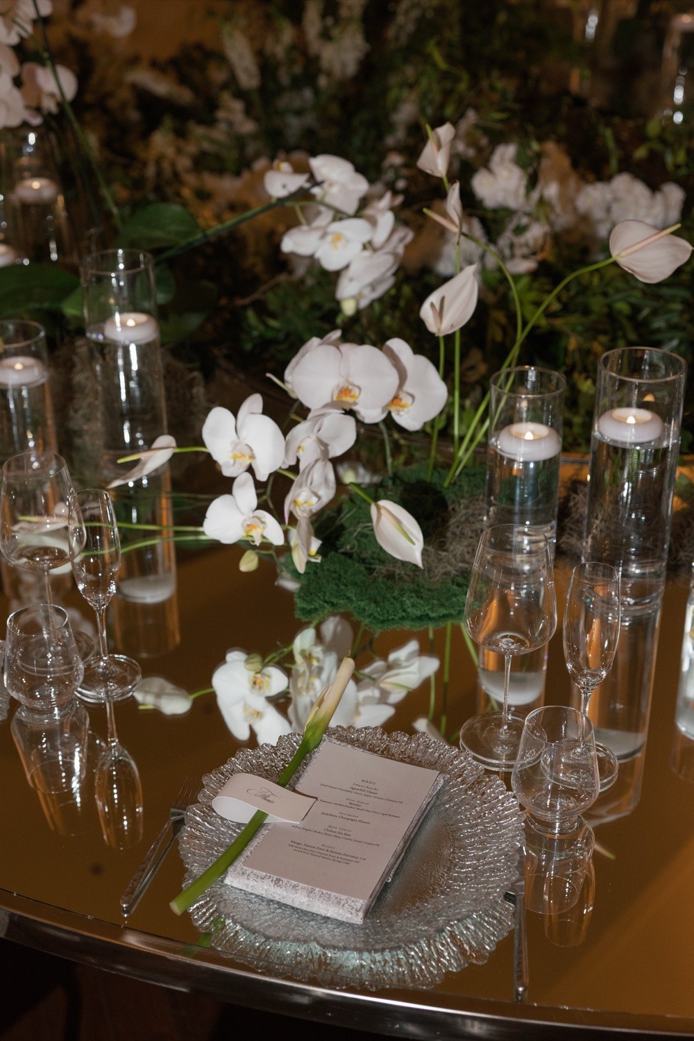 Orchid centerpiece and candlelit place setting at Nekajui