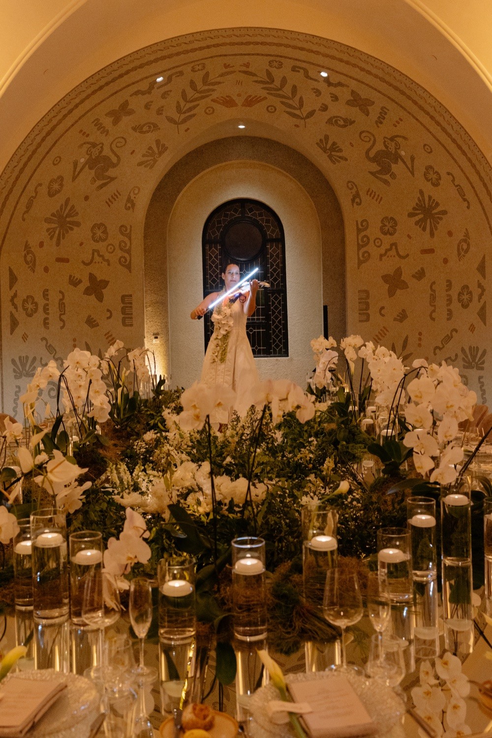 Violinist framed by an arch during a floral banquet at Nekajui