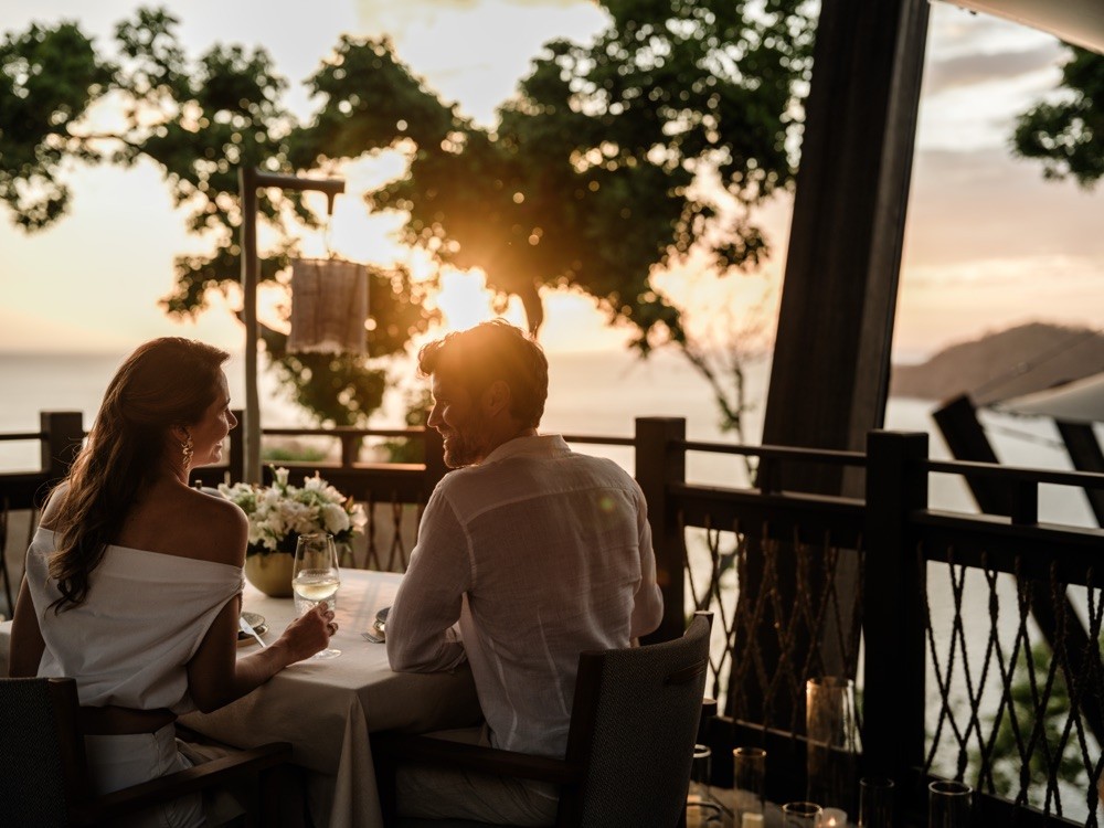 Couple dining on a sunset terrace at Nekajui