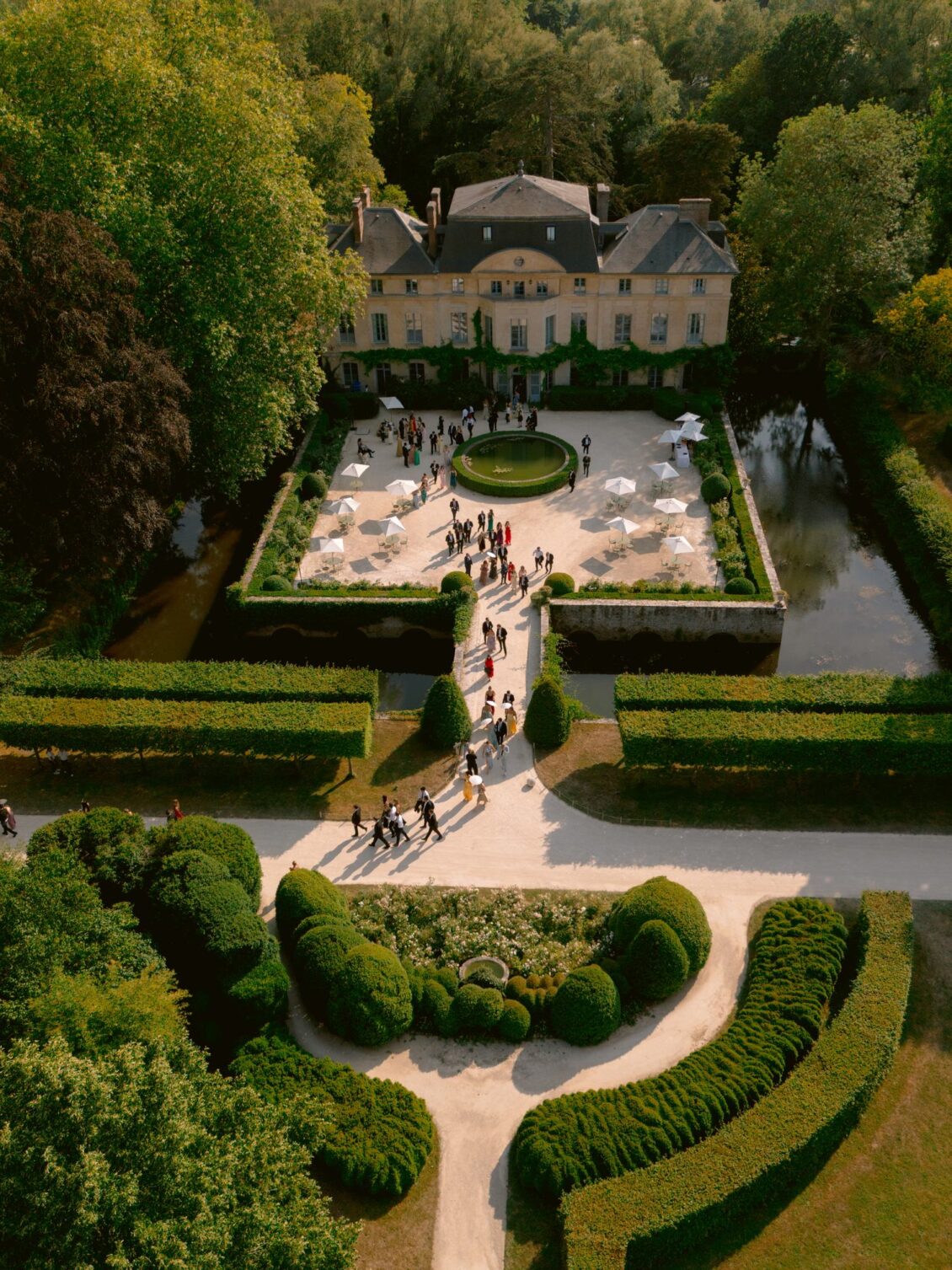 Aerial view of the château at Domaine de Primard with its parterre gardens and guests gathering