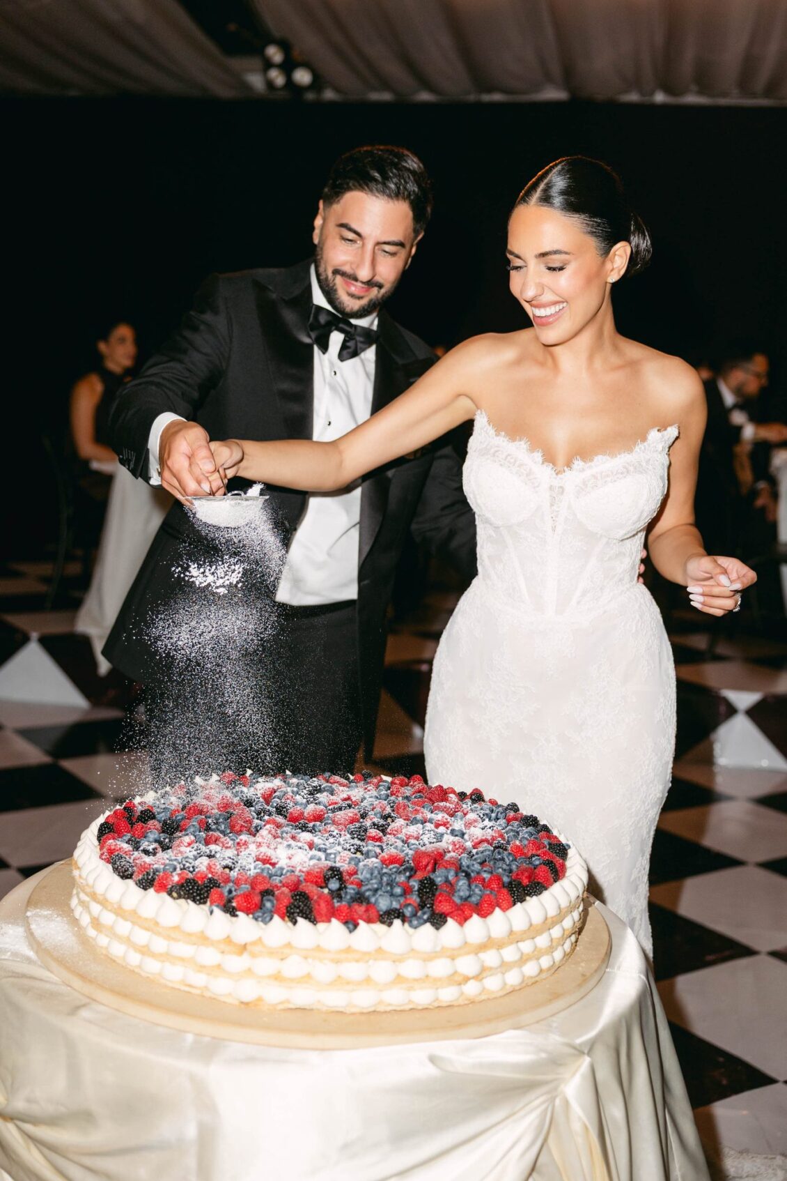 Lara and Alex dust a berry-topped millefoglie cake with powdered sugar