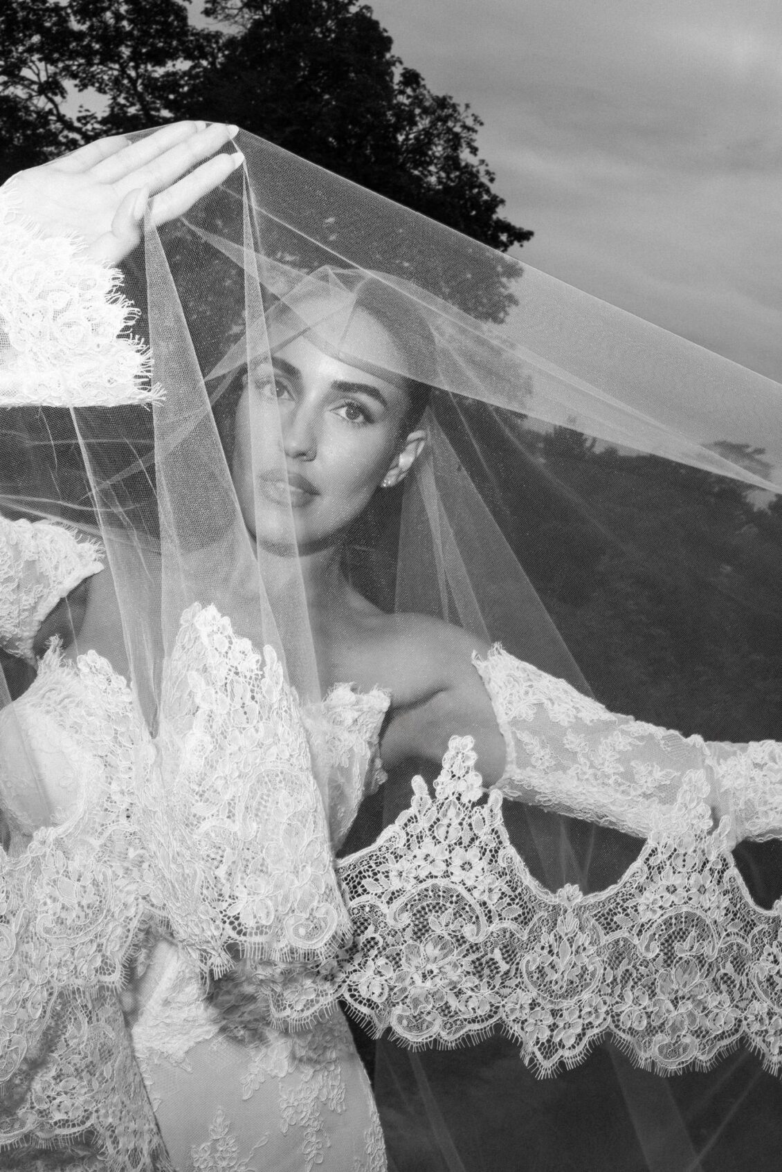 Black and white portrait of Lara looking out through her lace cathedral veil