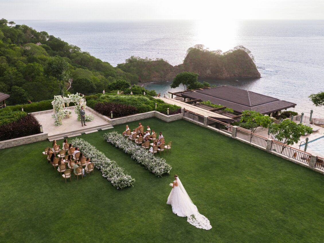 Bride walking toward the groom at an oceanfront wedding ceremony at Nekajui in Costa Rica