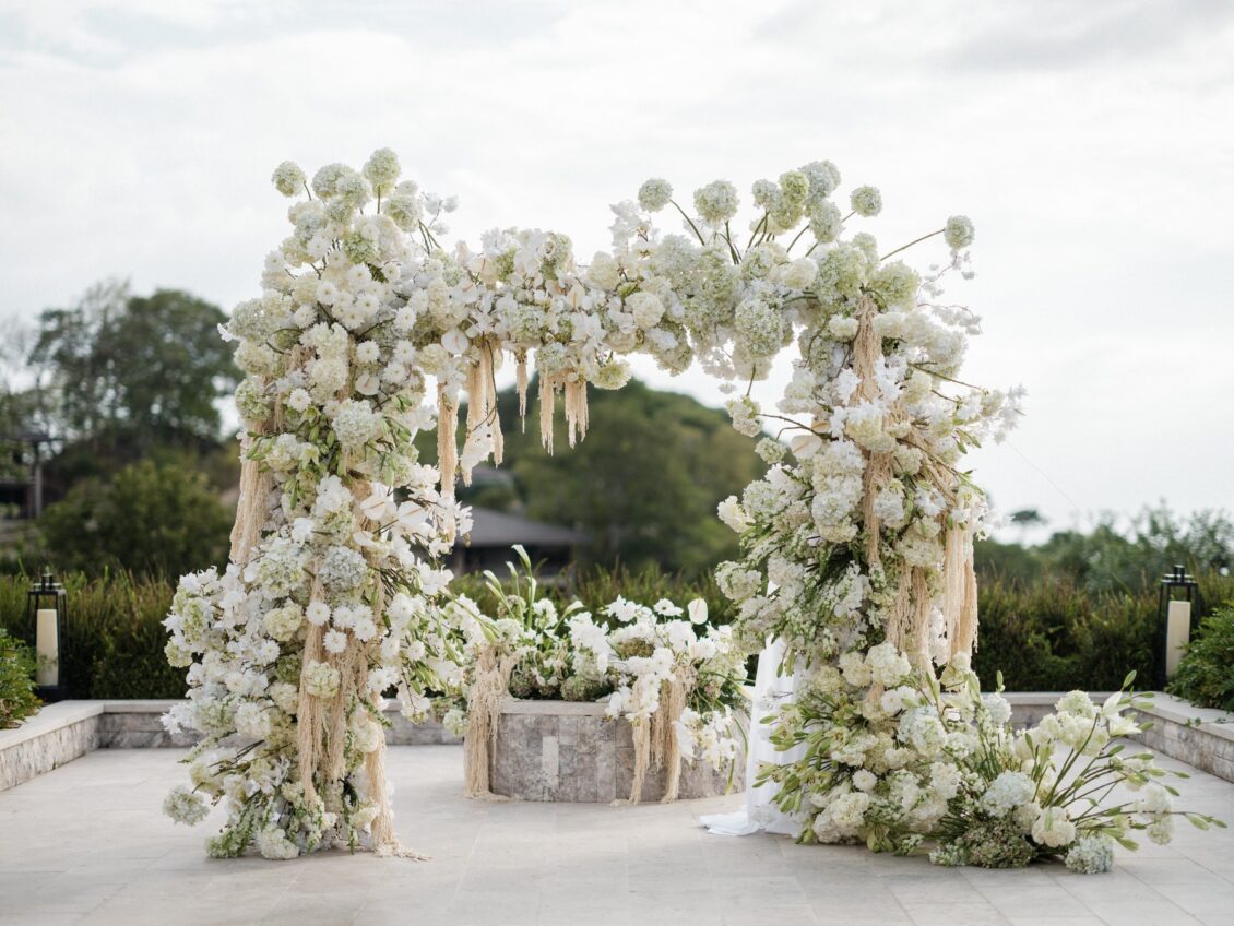 White orchids, hydrangeas, and trailing flowers on a ceremony arch at Nekajui, Costa Rica