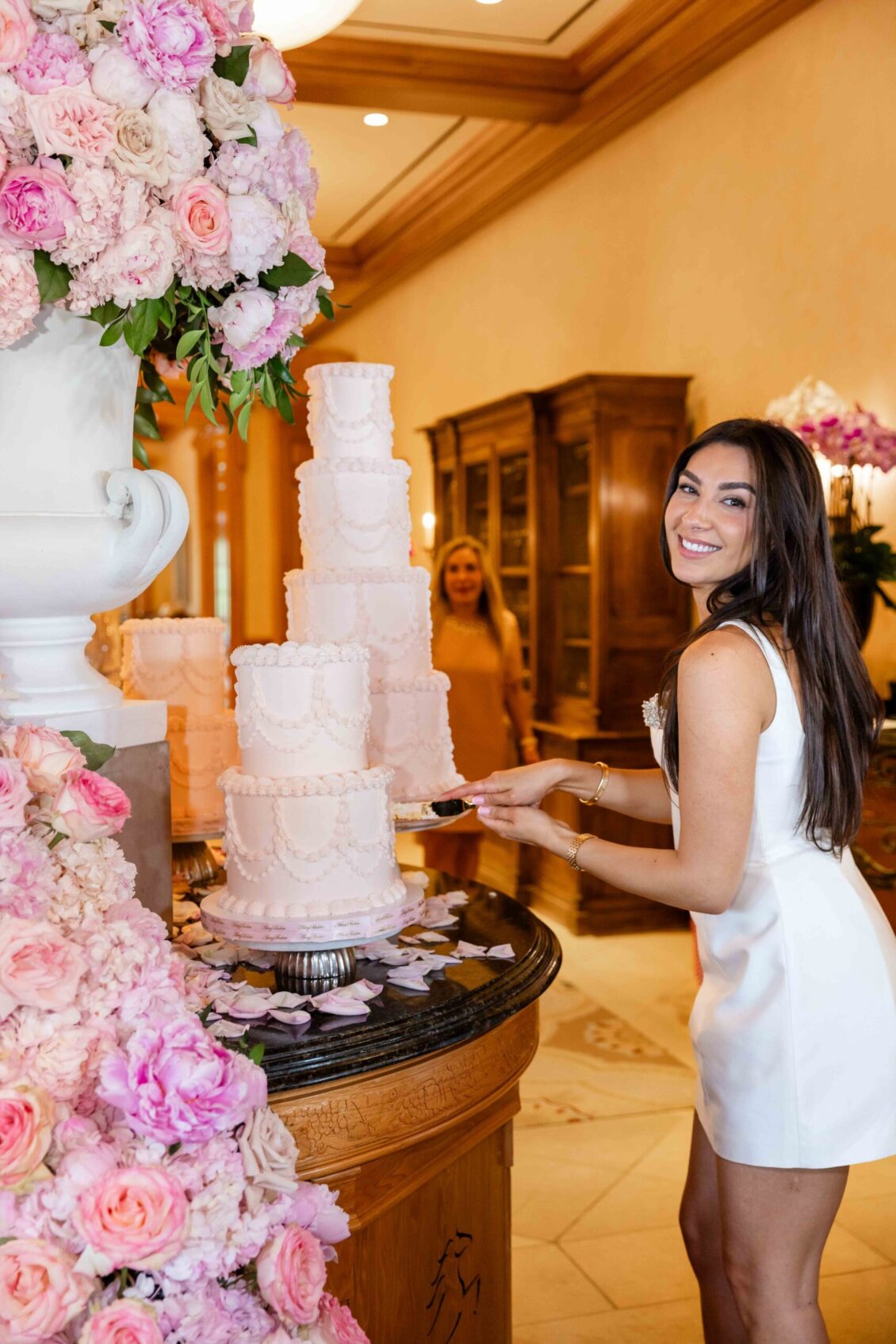 A smiling guest posed beside the tiered white cake
