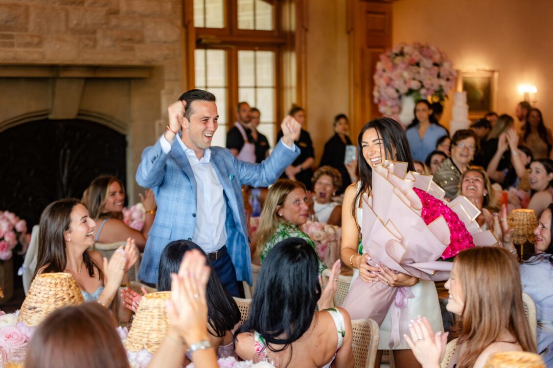 A joyful entrance through guests holding pink roses