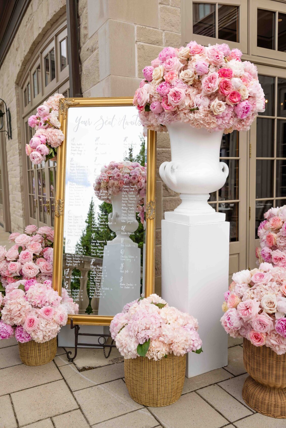 Pink floral installation arranged beneath an ornate gold mirror