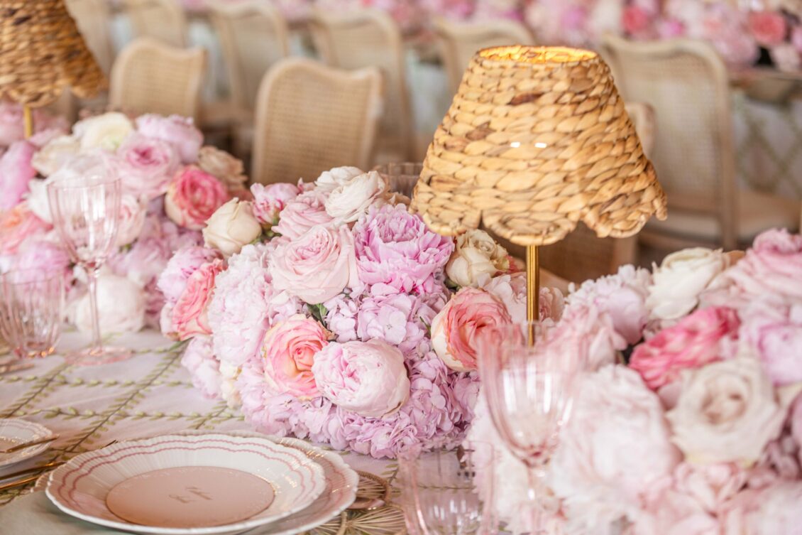 Wicker pendant lights and lush pink centerpieces above the bridal shower tables