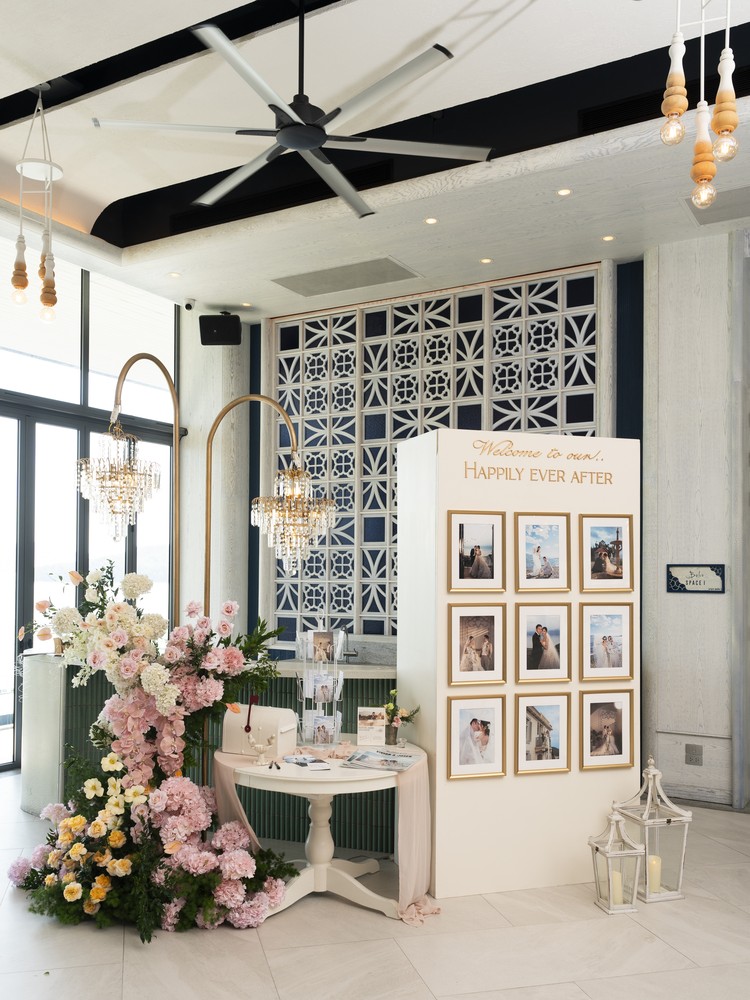 Vivian and Josen’s romantic destination wedding at Trisara Phuket — welcome and photo display with flowers and chandeliers