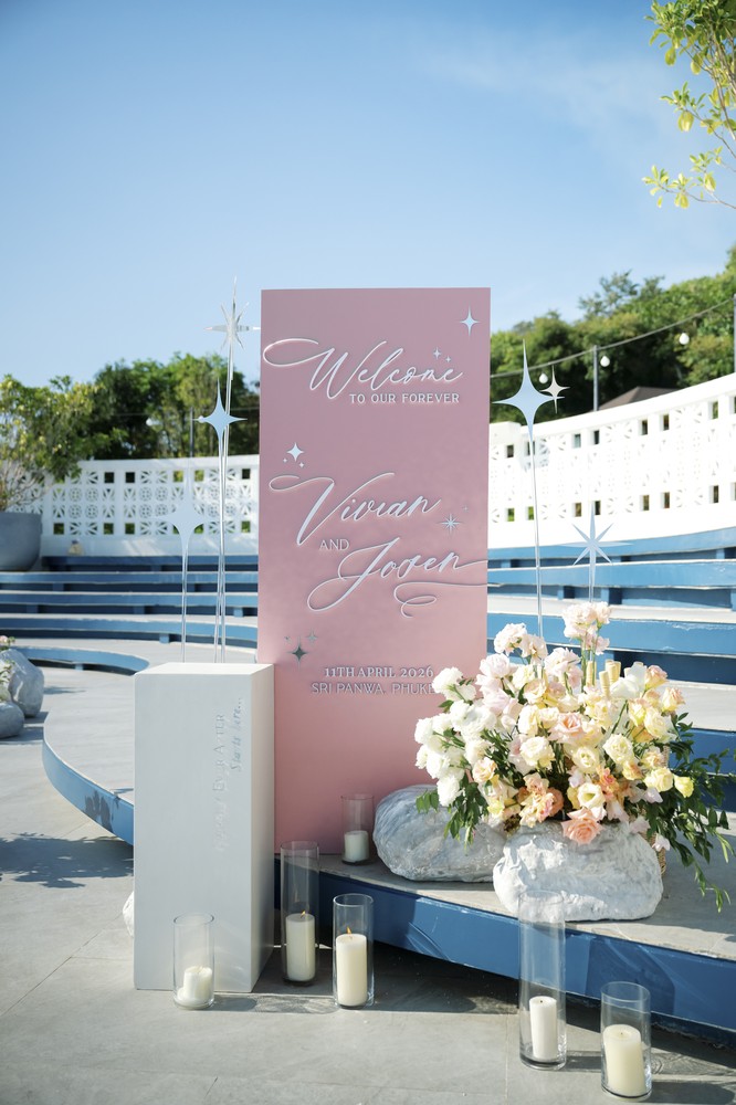 Vivian and Josen’s romantic destination wedding at Trisara Phuket — pink welcome sign with flowers and candles